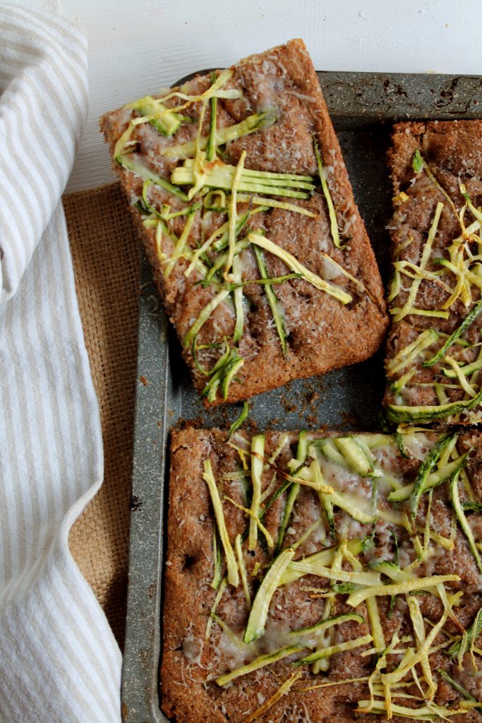 Focaccia integrale con zucchine nella teglia, porzionata